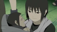 Sasuke being held by Itachi.