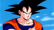 Goku stops above a deserted area, clutching at his chest in pain