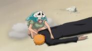 Ichigo lies on the ground after Nel brings him to a safer spot.