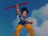 Goku smiling while holding his power pole.