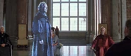 Senator Palpatine speaking to the Naboo Royal Advisory Council through a hologram.