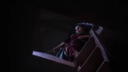 Gothel struggling to drag Rapunzel into the tower's secret entrance as the girl keeps fighting to break free from her chains.
