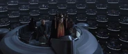 Palpatine sitting down as Queen Amidala goes to speak to the Senate.