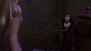 Gothel standing in shock as Rapunzel questions her.