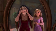 Gothel admiring her reflection as Rapunzel tries to talk to her.