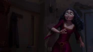 A shocked Gothel having broken free from Rapunzel's grip, causing a mirror to shatter.