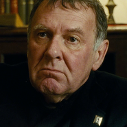 Padre Oliver(Tom Wilkinson) en El gran pequeño su último trabajo antes de su fallecimiento.