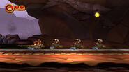 Donkey Kong inside a mine cart reaching some Skellirexes also riding mine carts (Wii version).