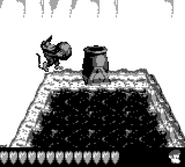 Diddy Kong about to throw a Kannonball at a Kannon, as seen in the game Donkey Kong Land 2 for Game Boy.