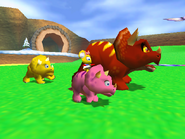 Pipsy riding a pink triceratops with Tricky and a yellow triceratops in the background.