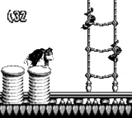 Donkey Kong moving towards some ropes where two Slippas sliding down by moving around ropes, as seen in the game Donkey Kong Land for Game Boy.