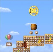 Donkey Kong aproaching a DK Coin inside a stage, as seen in the game DK: Jungle Climber for DS.