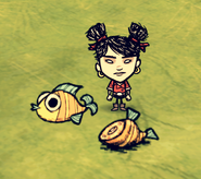 Walani standing next to a Pierrot Fish and a Cooked Pierrot Fish on the ground.