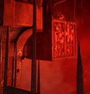 На первой части локации Некравол она находится за решёткой, расположившись на клетке с измученными людьми, подвешенной на цепях