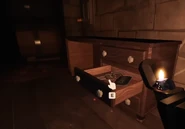 A Room Key inside a Container in the large basement, before removal.