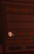 Lemonade Cat on a bookshelf in the lobby.