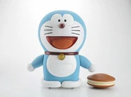 Một món đồ chơi Doraemon DTR-01B với cái đồ điều khiển hình bánh rán