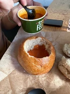 Spooning Tomato Soup into the Bread Bowl