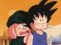 Oolong hiding behind goku