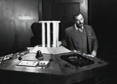 The Doctor standing at the console.