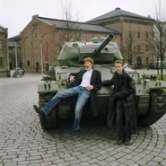 Matt (left) and Tord (right) leaning against a tank.