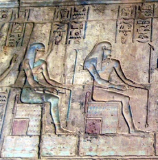 Keket (left) and Kek (right) sitting on thrones at a relief from a temple at