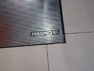 Older 1990s Hyundai logo on an escalator landing plate.