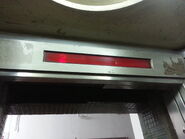 Horizontal floor indicator above doors which using Red illuminated numbers.