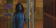 Nadia holding the door open in Frutería Shanaa S01E04