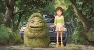 Chihiro junto a la estatua de entrada.