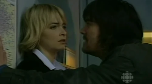 Cain pins Charity against a wall and is about to slap her in April 2004