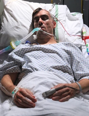 Cain in hospital after his attack