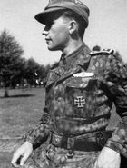 Hauptsturmführer Miervaldis Ādamsons of the 19th Waffen Grenadier Division of the SS (2nd Latvian) wearing an M44 Erbsenmuster Feldbluse tucked in his trousers[53]