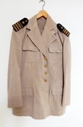 The khaki (late) Navy version of M-77 service uniform, featuring later version of Kapetan fregate rank epaulettes (featuring a star instead of anchor) on its shoulder boards.