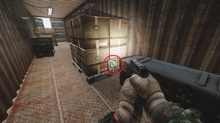 1. Caché derrière une palette de cartons au fond du conteneur.