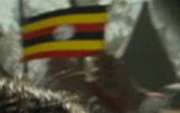 Un asistente de la  ondeando una bandera de Uganda.