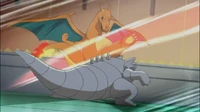 Charizard de Rojo usando mega patada contra el Rhydon de Giovanni.