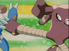 Hitmonlee de Shiro usando patada salto sobre el Hitmontop de Chigusa.