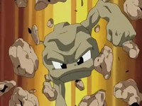 Geodude de Roxanne/Petra usando lanzarrocas. Da un gran golpe al suelo rocoso...