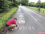 香港攝影師楊德銘在公路計時賽決賽的公路上，用粉筆寫下「平反六四」。