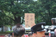 一名男子高舉「中國人滾回中國」標語