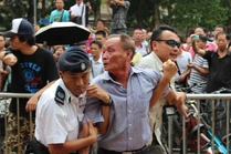 該名長者再次衝向揮舞香港旗的男子，將旗扯下後被警方帶走