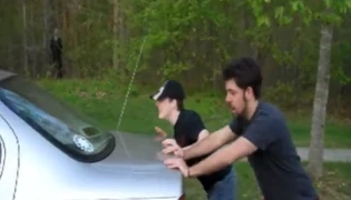 Evan and Vince pushing a car.