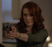 Sharon pointing her gun at Peter Harken