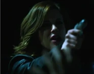 Nina pointing her gun at Elijah Mundo