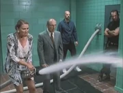 The vicious woman cools off the girl with the fire hose.