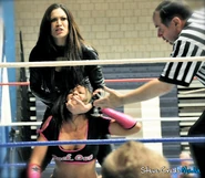 The evil Melina snarling at the crowd while torturing Velvet Sky