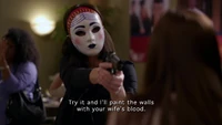 In her mask, she threatens a foreign couple who were planning to run