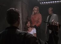 Jasmine (Katerina Brozova) holds a gun on her hostage (with Judge Reinhold, Carol Alt and Michael Sarrazin)