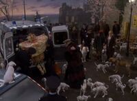 Evil Cruella is loaded into a police van as the victorious dalmatians look on!